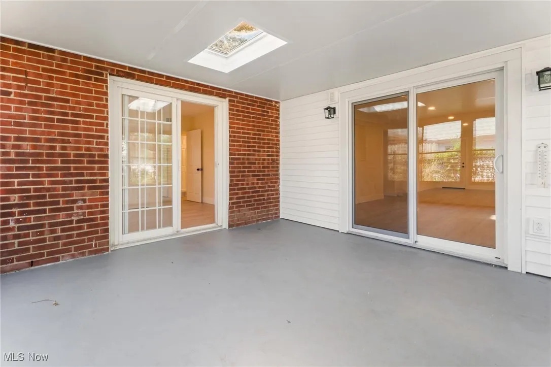Unfurnished sunroom featuring a skylight