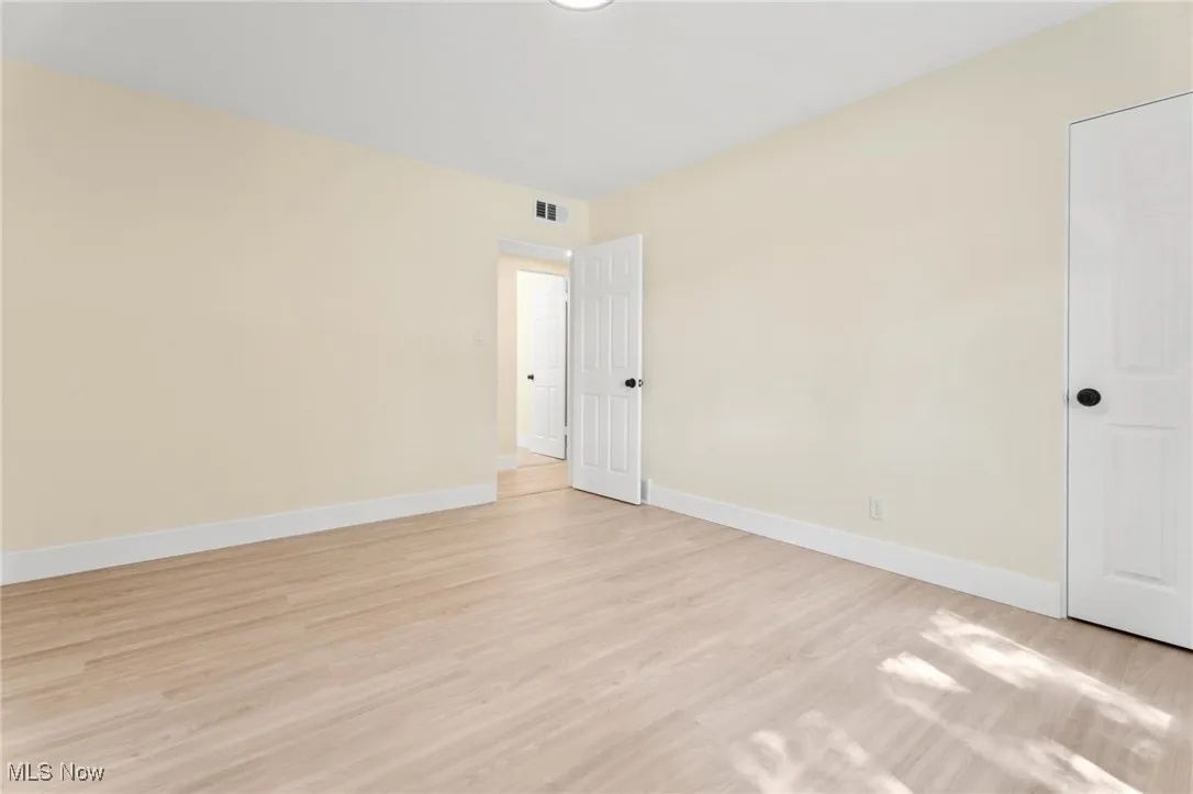 Unfurnished room featuring baseboards and light wood-style flooring