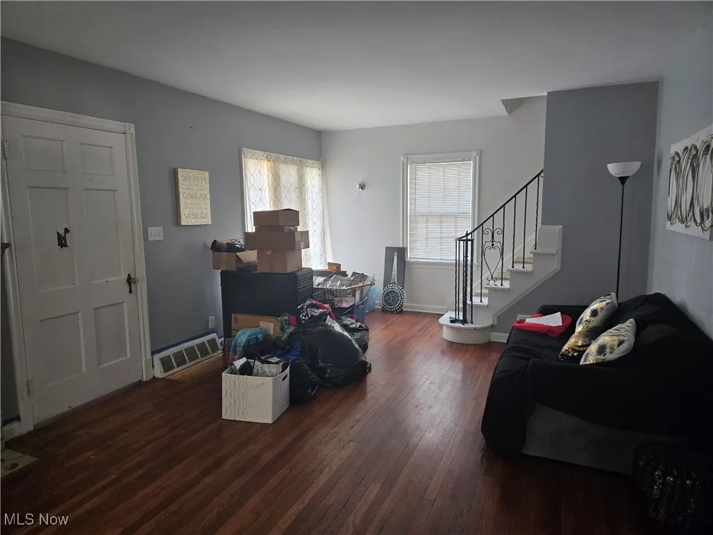 Living area featuring stairs and dark wood-style floors
