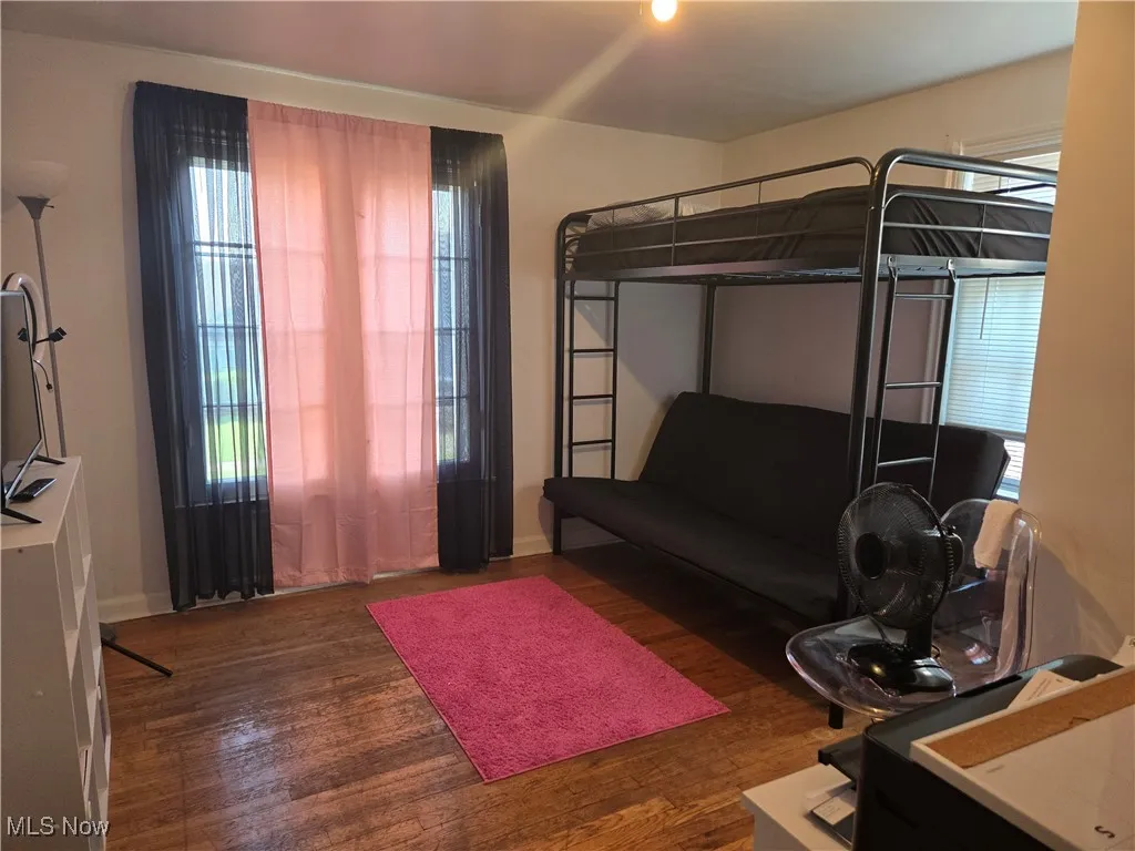Bedroom featuring multiple windows and dark wood-style flooring