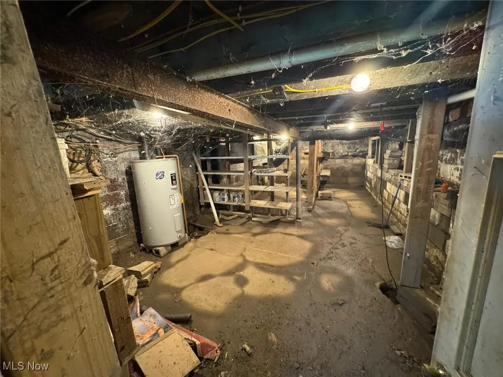 Unfinished basement featuring electric water heater