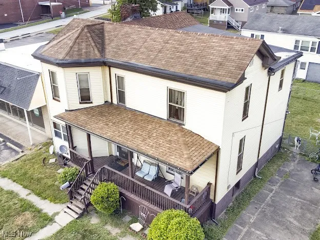 Rear view of property with roof with shingles, a wooden deck, and stairs