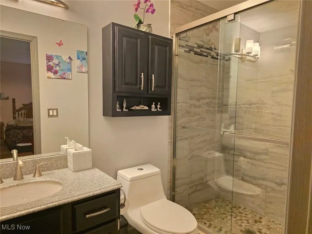 Ensuite bathroom featuring vanity and a stall shower