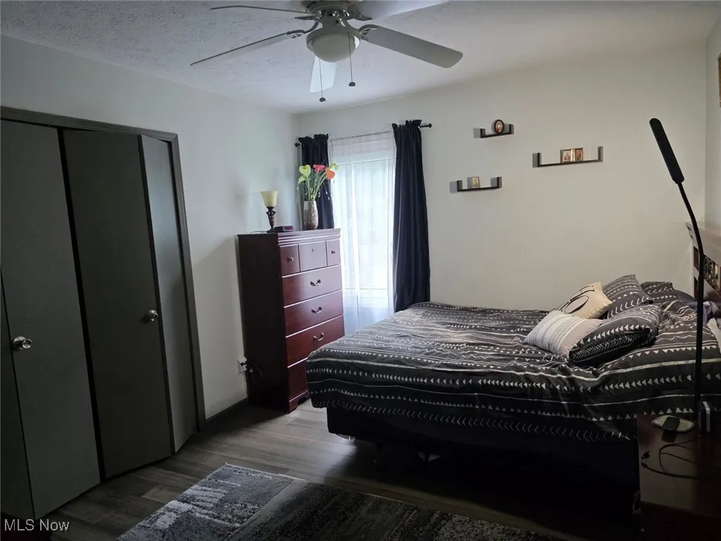 Bedroom featuring wood finished floors, a closet, ceiling fan, and a textured ceiling