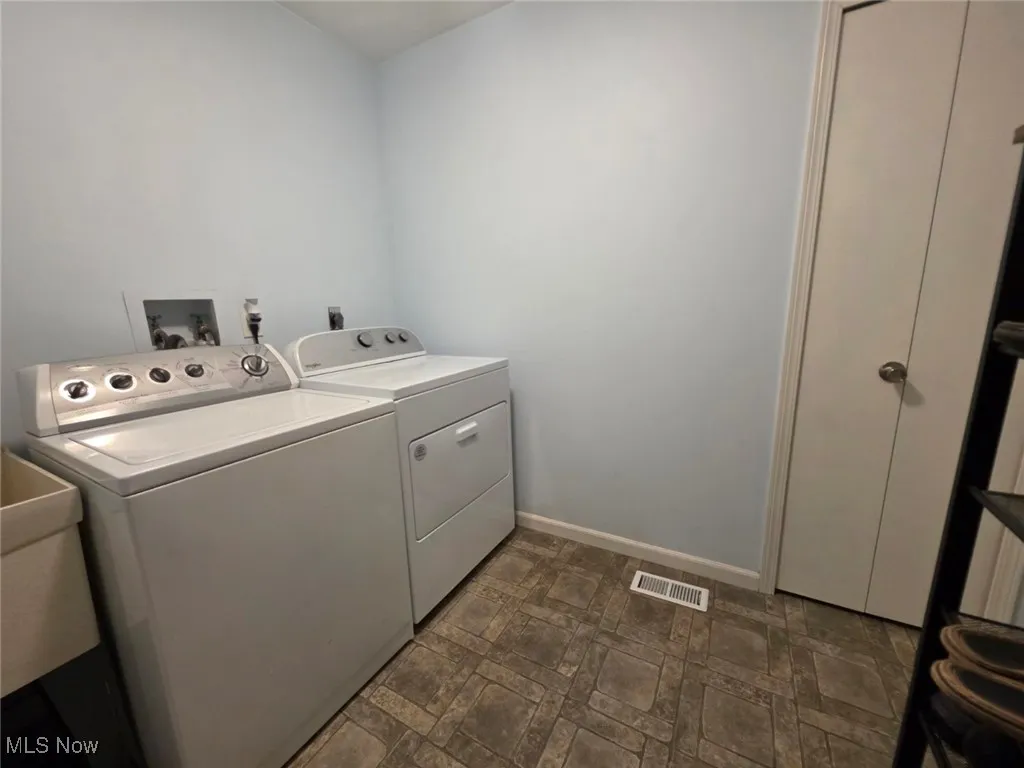 Laundry room with baseboards and washing machine and dryer