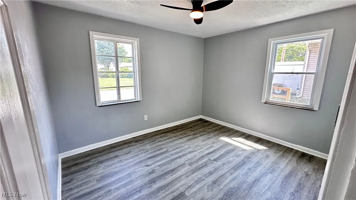 Unfurnished room featuring wood finished floors, a textured ceiling, and ceiling fan