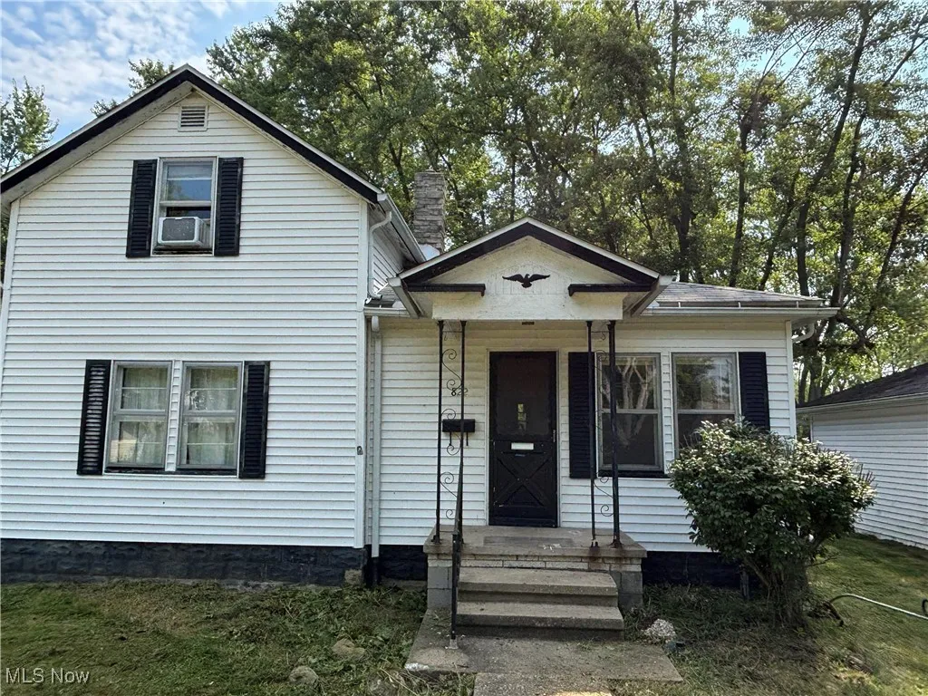 View of front of home with a chimney and a front lawn