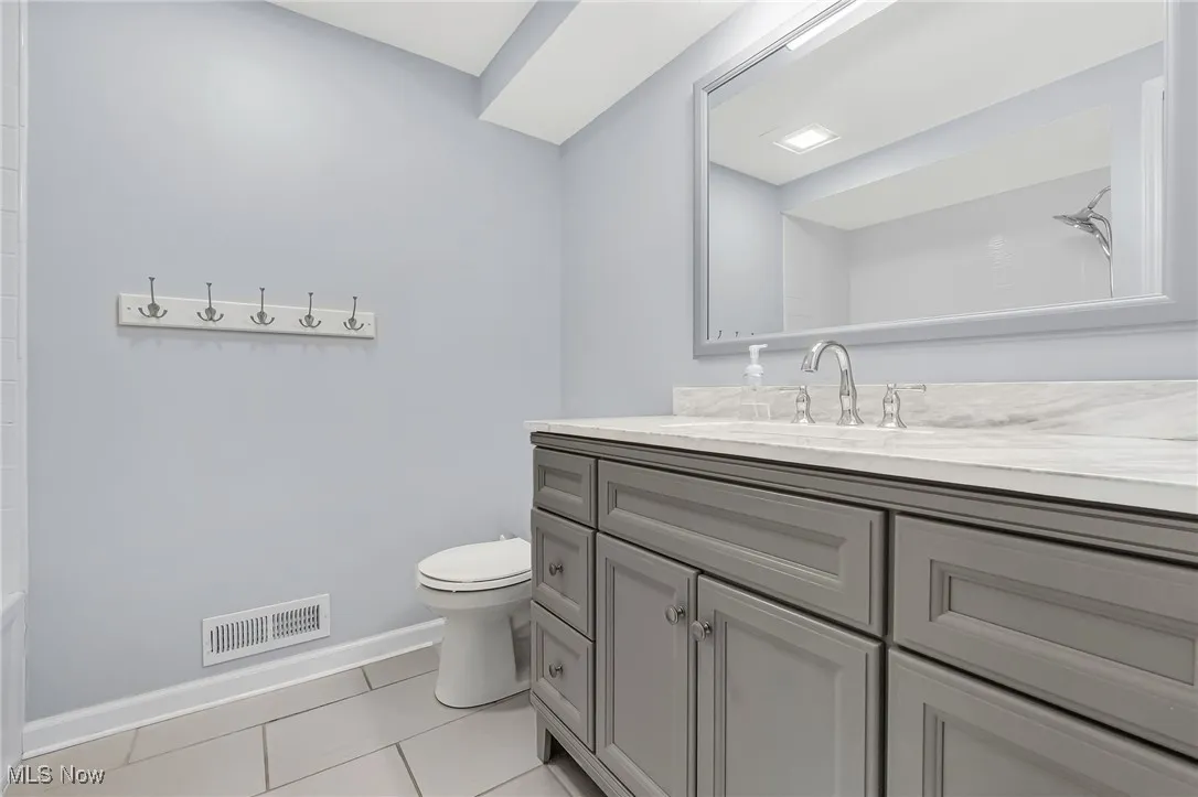 Bathroom with light tile patterned floors and vanity