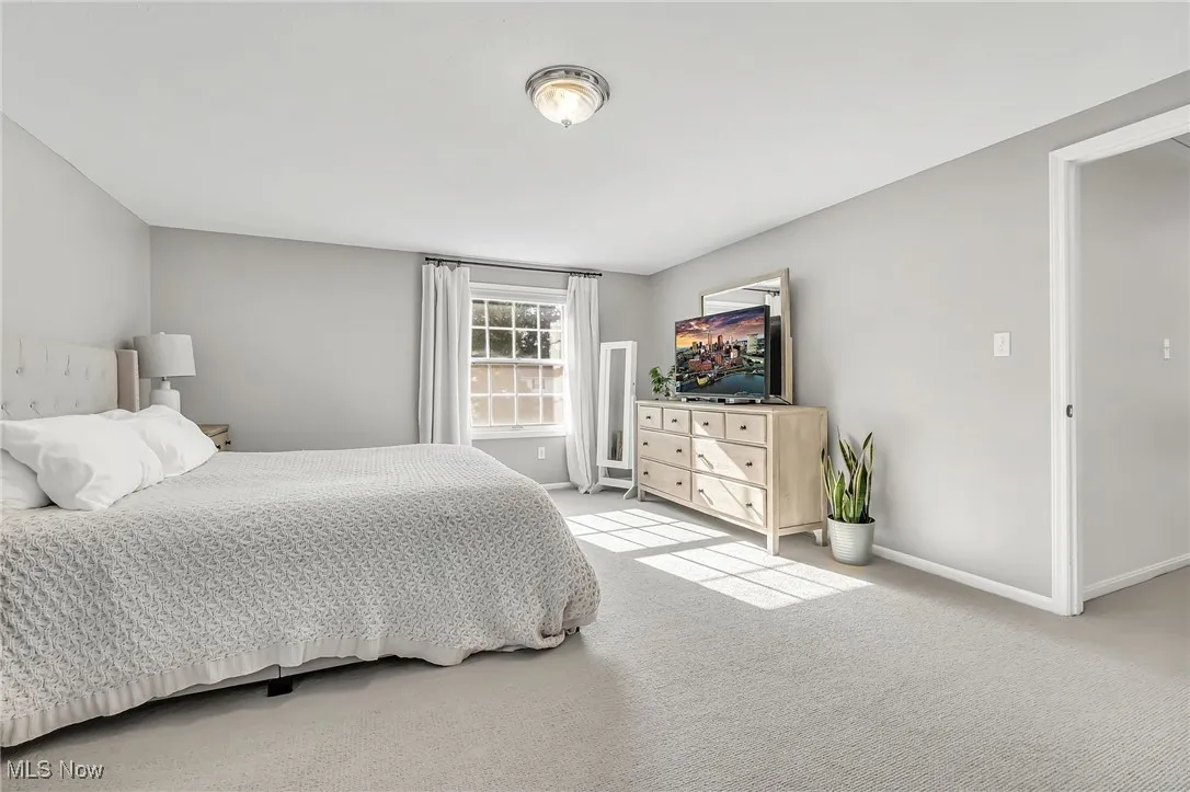 Bedroom featuring light colored carpet and baseboards