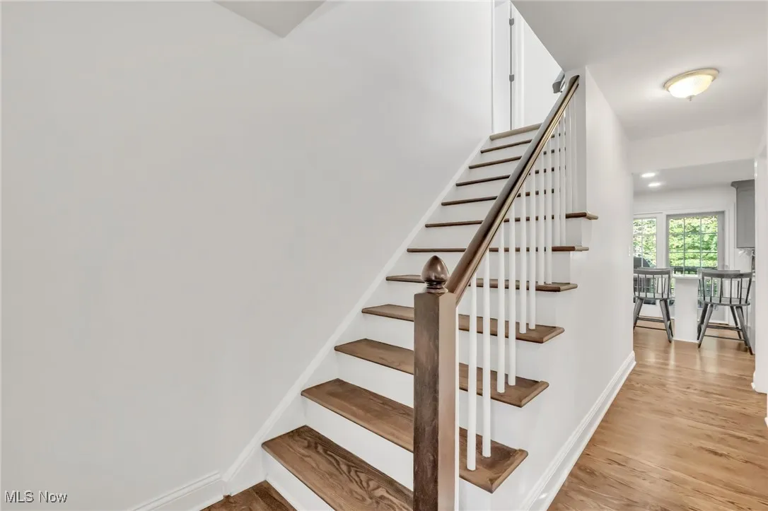 Staircase with wood finished floors and recessed lighting