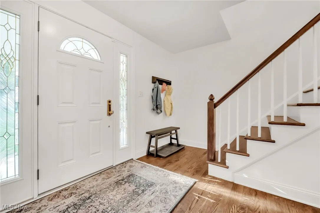 Foyer featuring wood finished floors and stairs