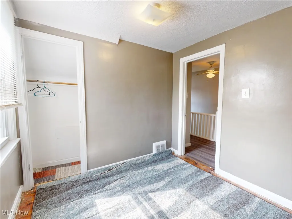 Unfurnished bedroom featuring a textured ceiling and wood finished floors