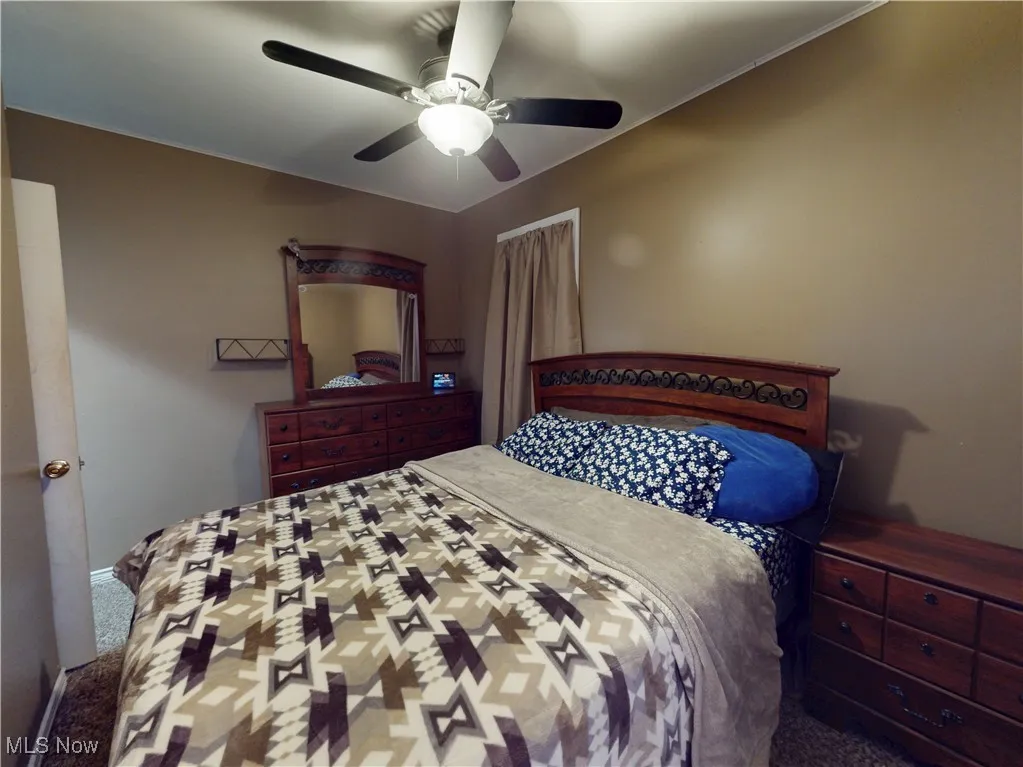 Carpeted bedroom with ceiling fan