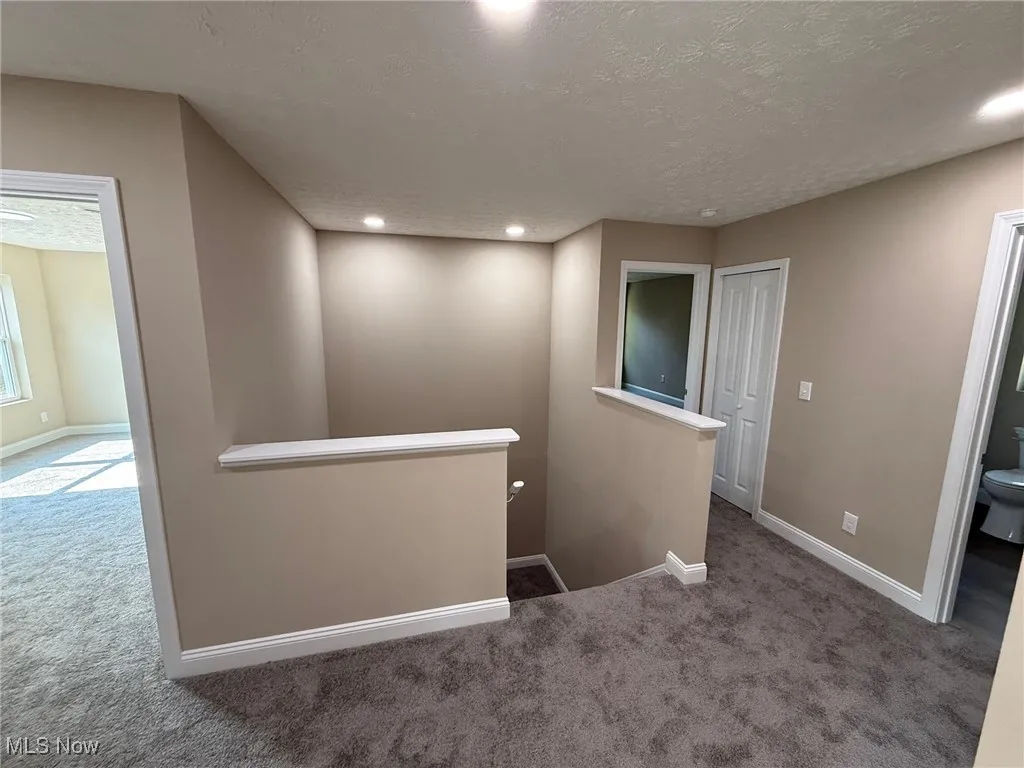 Spare room with carpet flooring, a textured ceiling, and recessed lighting