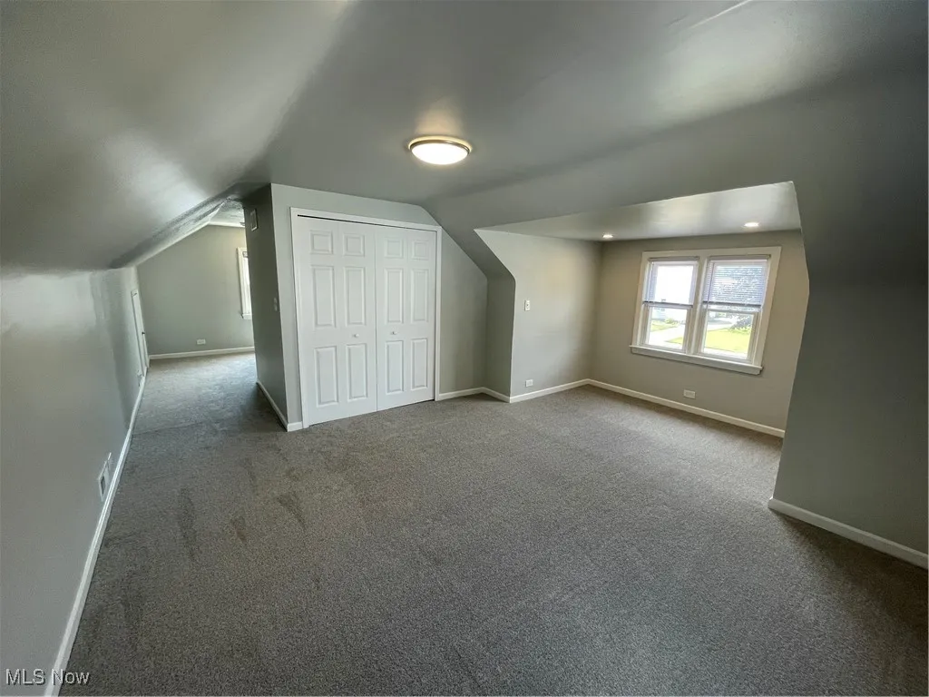 Bedroom featuring carpet floors and vaulted ceiling