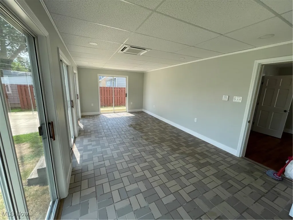 Sun room with a drop ceiling and baseboards