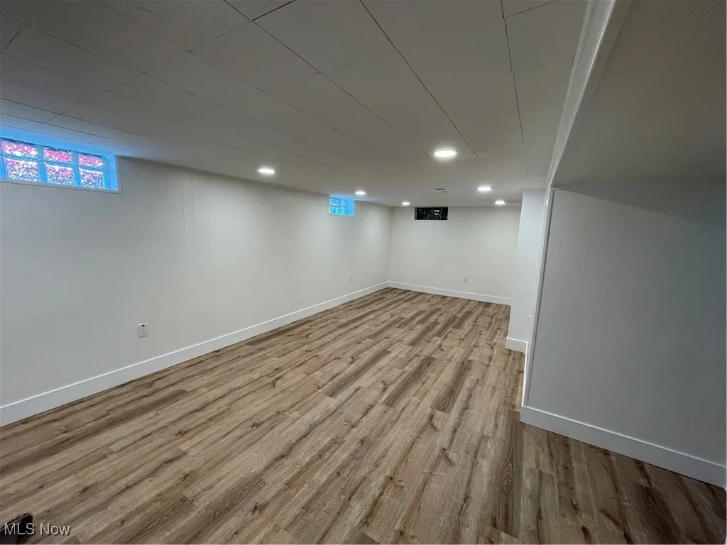 Basement featuring healthy amount of natural light and light wood-type flooring