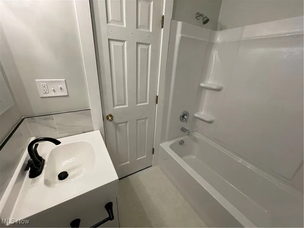 Full bath featuring washtub / shower combination and vanity