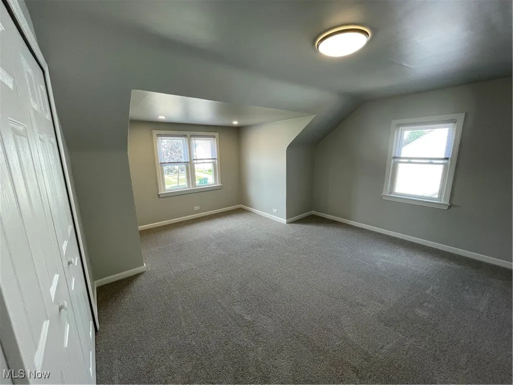 Bedroom with vaulted ceiling and carpet flooring