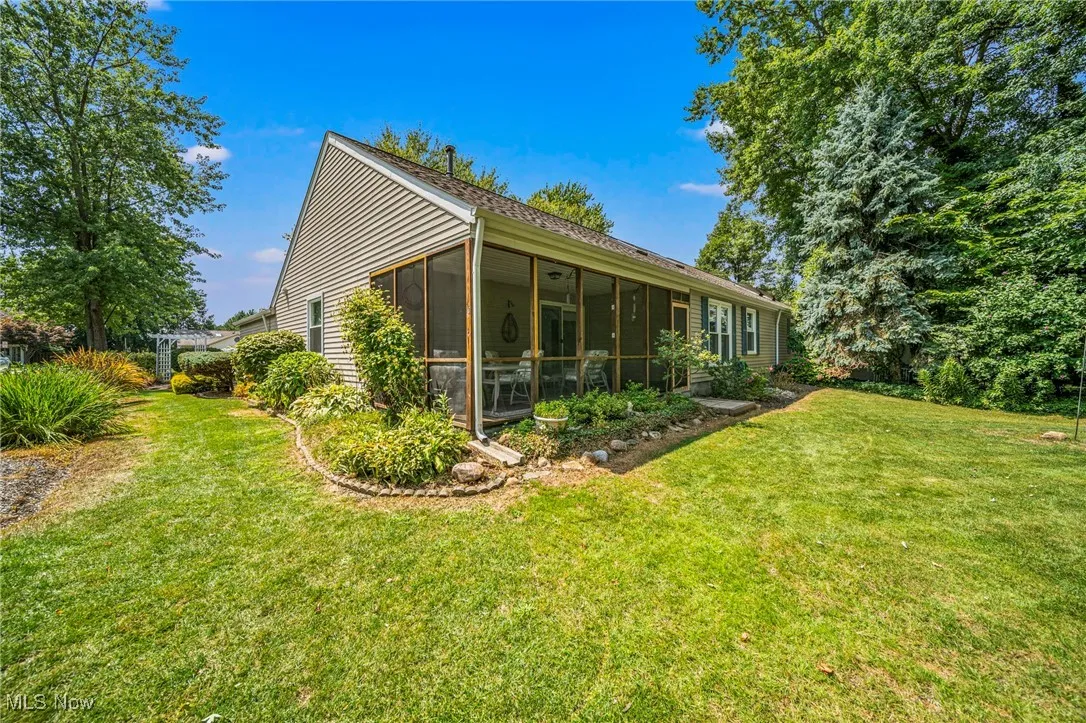 Back of property featuring a lawn and a sunroom