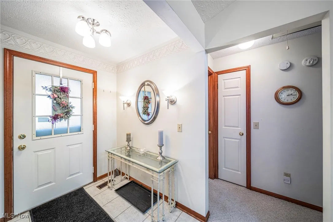 Foyer with a textured ceiling and light tile patterned floors