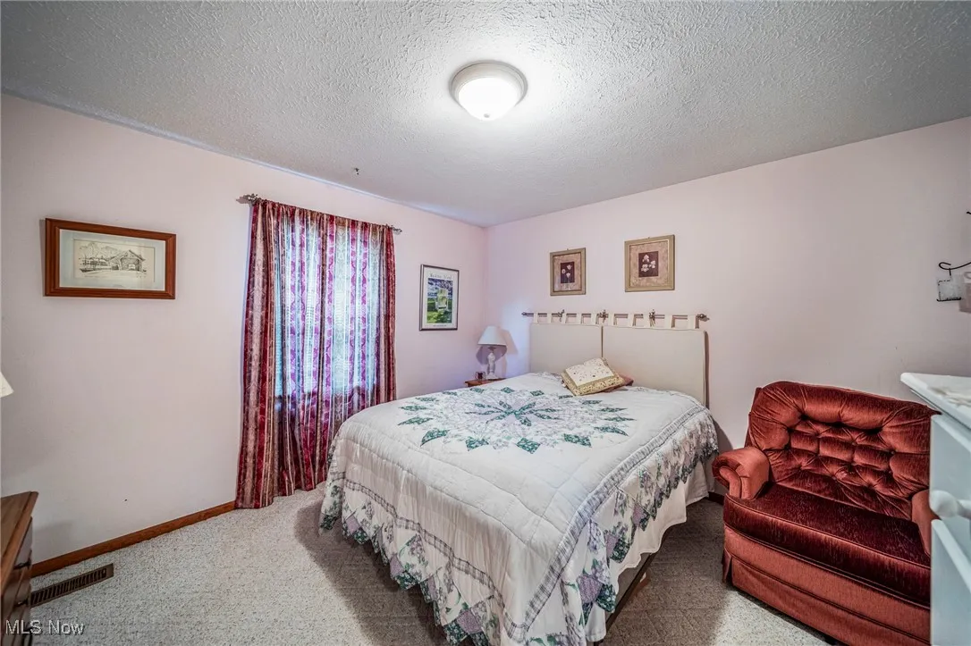 Bedroom with carpet floors and a textured ceiling