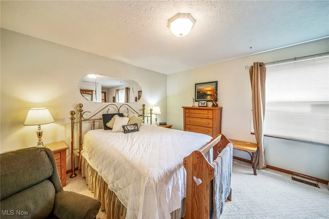 Bedroom featuring light carpet and a textured ceiling