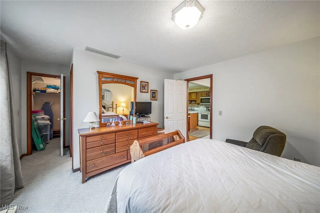 Bedroom with a textured ceiling and light colored carpet