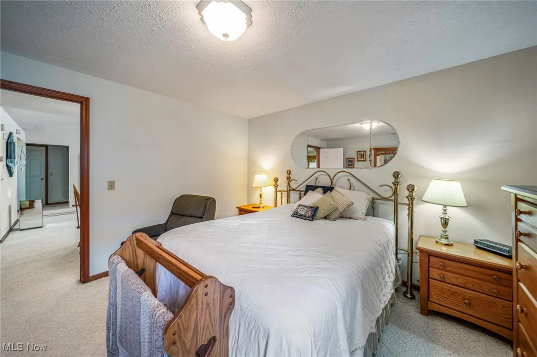 Bedroom featuring light carpet and a textured ceiling