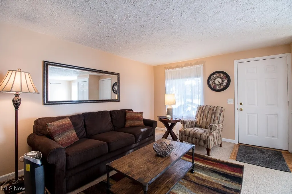 Living room featuring a textured ceiling and baseboards