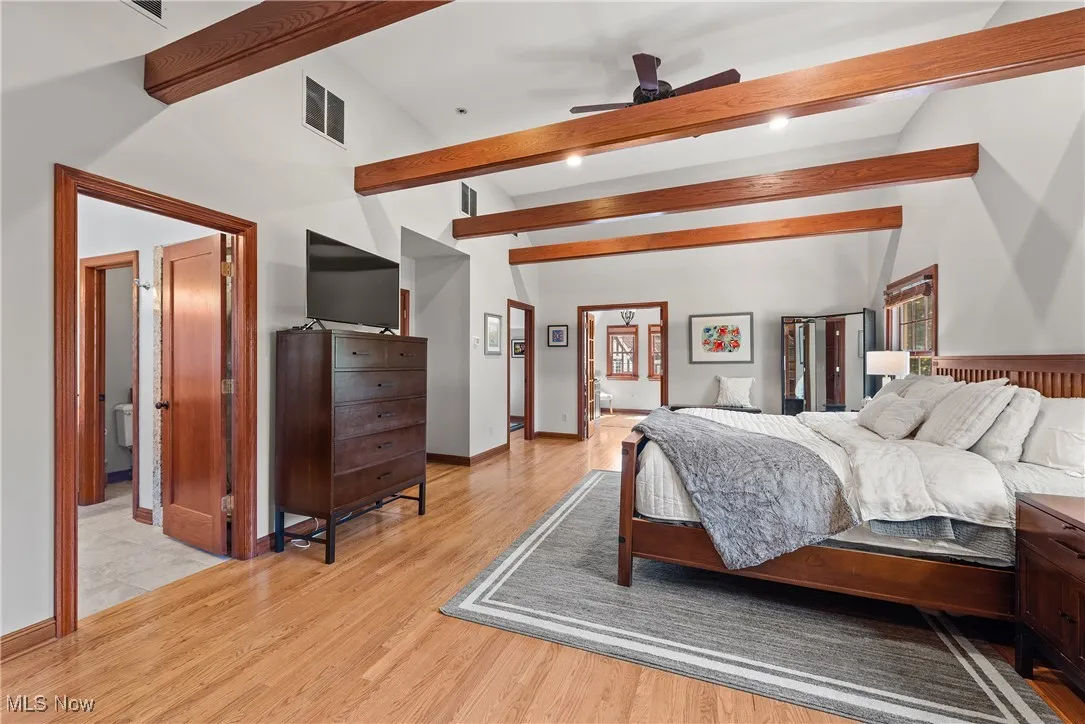 Bedroom with light wood-style floors and ensuite bathroom