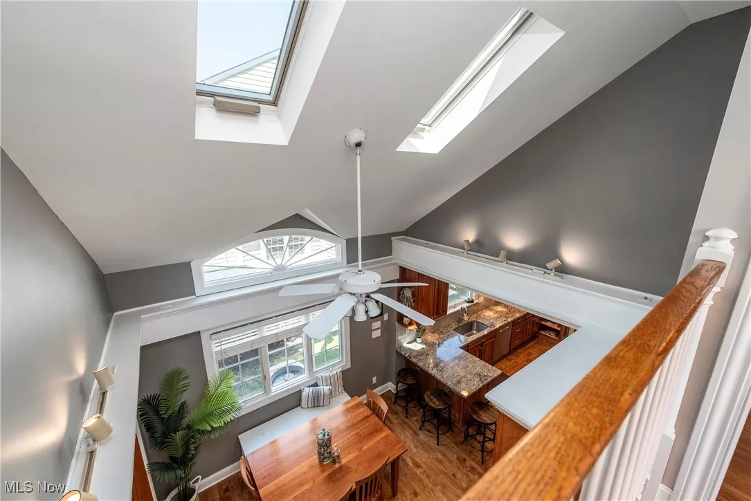  high vaulted ceiling, wood finished floors, and a skylight