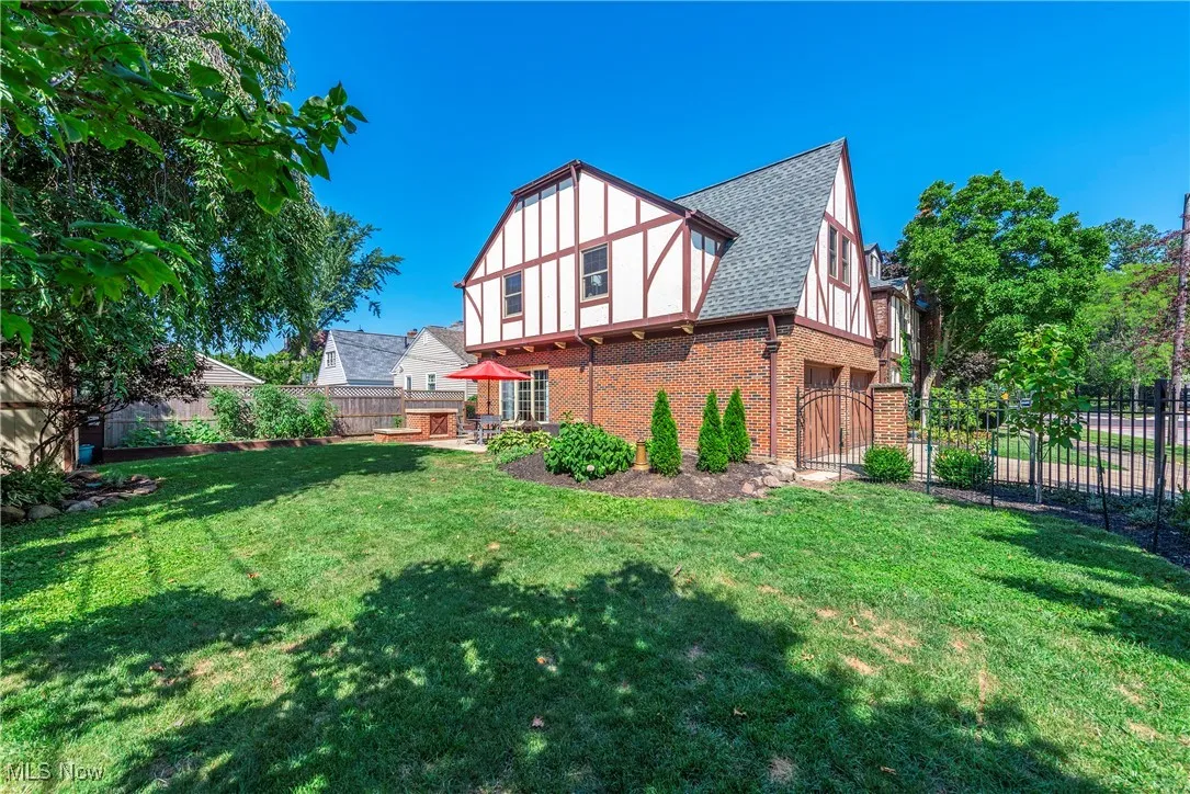Rear view of property featuring brick siding and roof with shingles