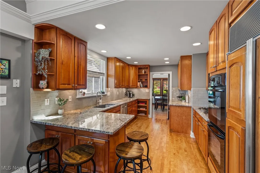 Kitchen with open shelves, light stone counters, healthy amount of natural light, and recessed lighting