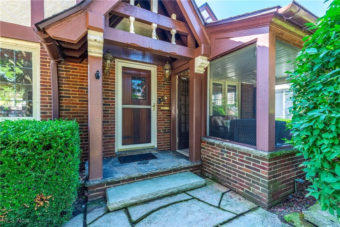 Doorway to property featuring brick siding