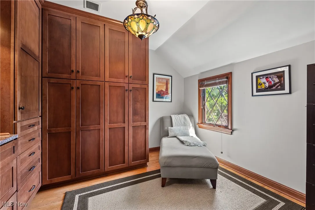 Sitting room with vaulted ceiling and light wood-type flooring