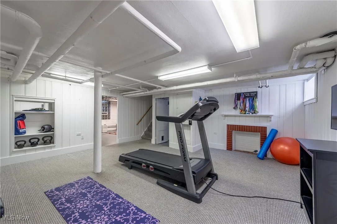 Workout room with carpet and wooden walls