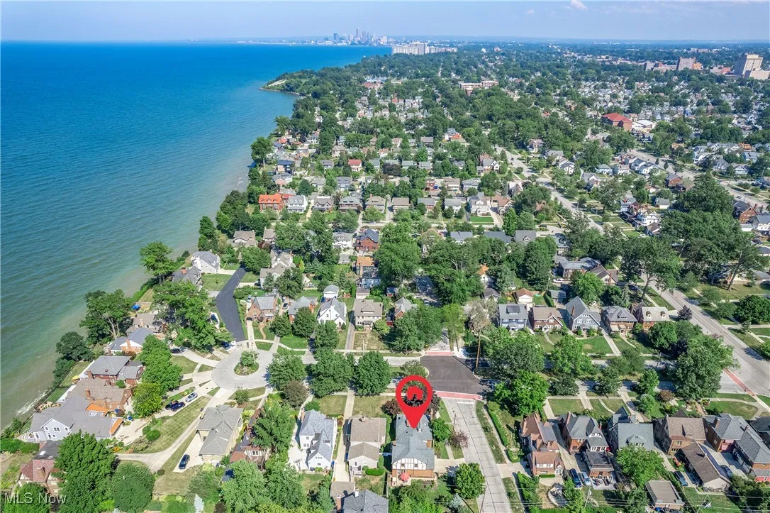 Aerial view of property and surrounding area with nearby suburban area and a large body of water
