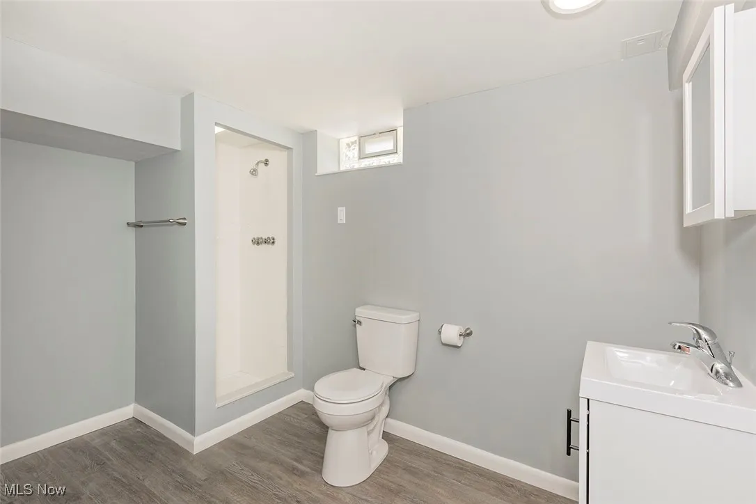 Bathroom with vanity, a shower stall, and light wood-type flooring