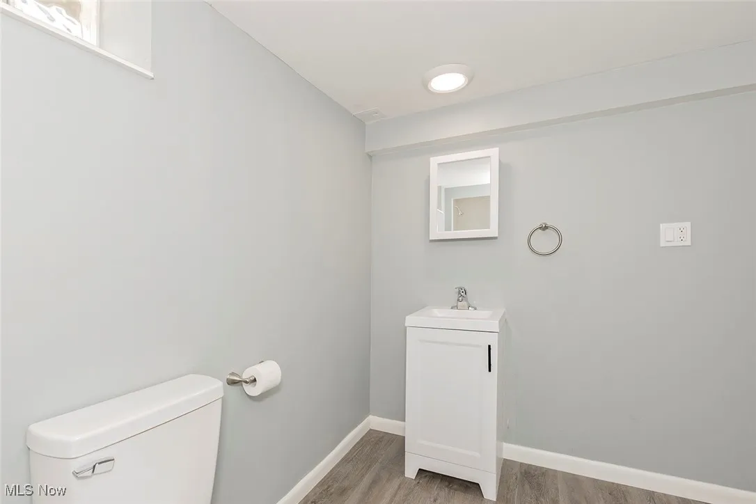 Half bathroom featuring vanity and light wood-style flooring