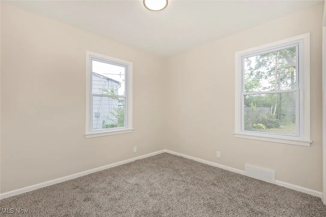 Carpeted empty room featuring baseboards