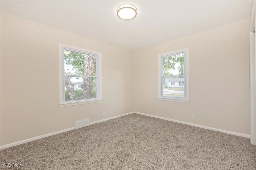 Carpeted empty room with baseboards