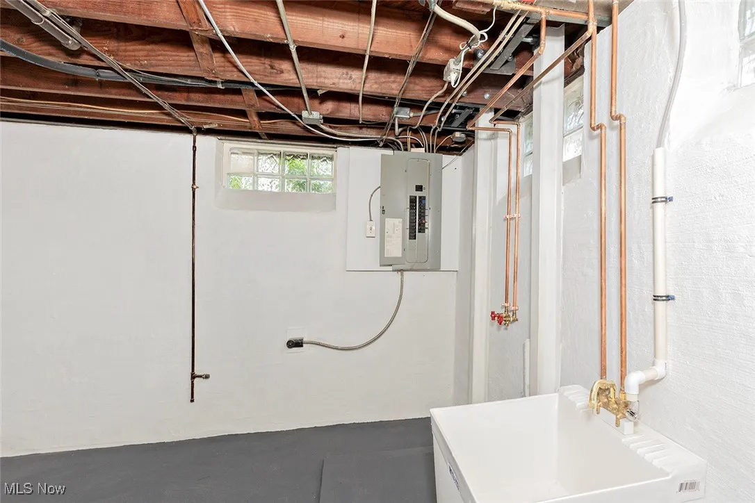 Basement with a sink and electric panel