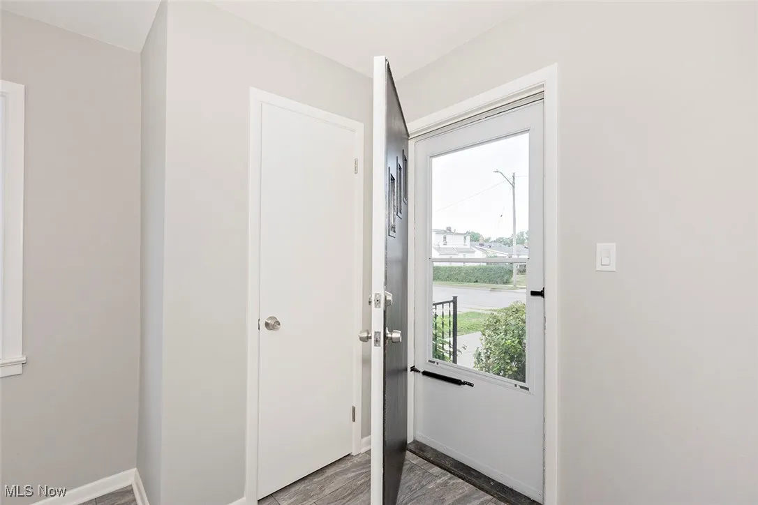 Doorway with baseboards and wood finished floors