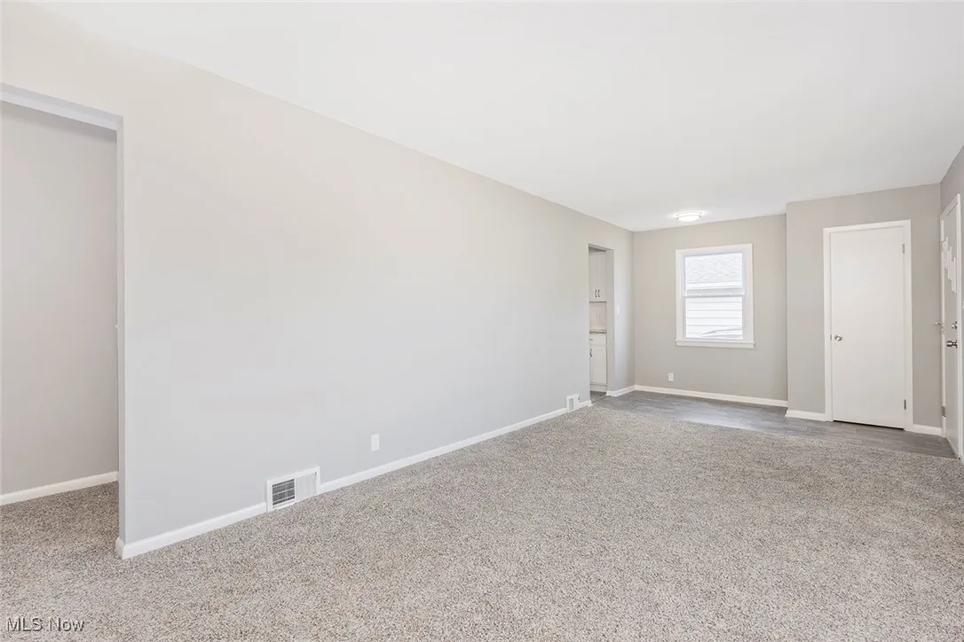 Carpeted empty room with baseboards