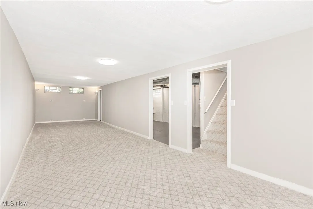 Below grade area with light carpet and stairs