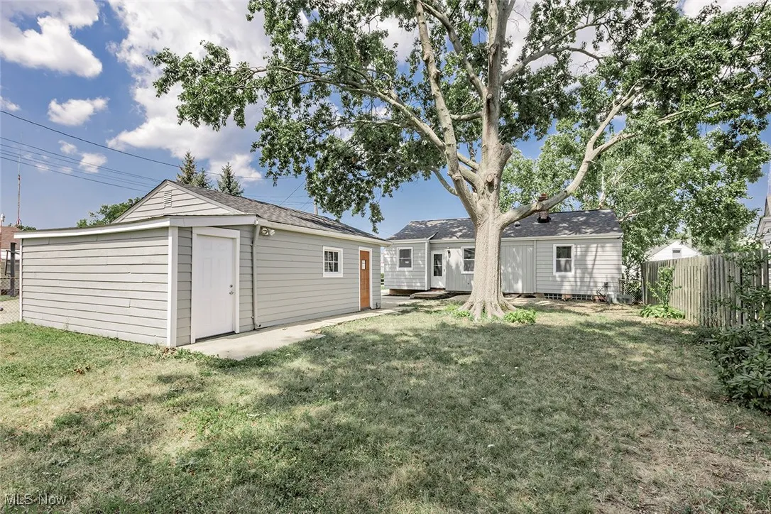 Rear view of property featuring a patio area and an outbuilding