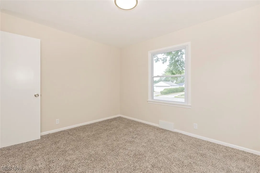 Spare room with baseboards and carpet floors