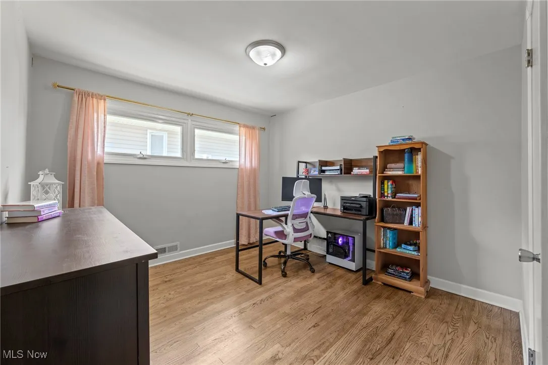 Home office featuring light wood finished floors and baseboards