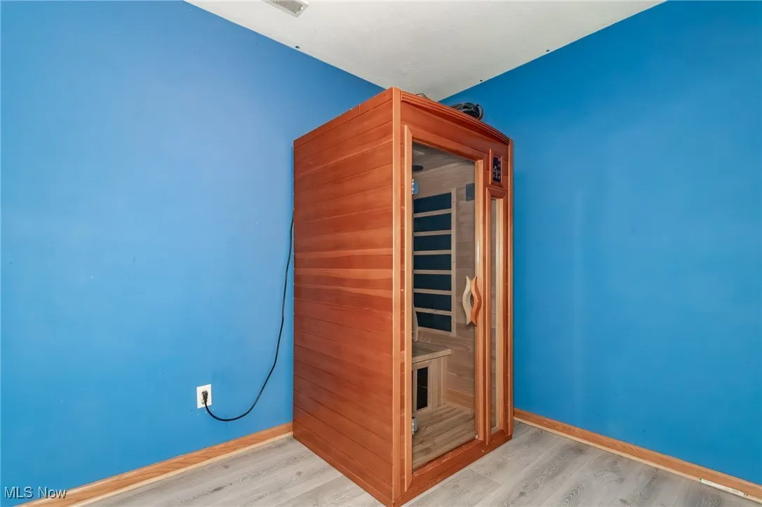 Sauna / steam room with wood finished floors and baseboards